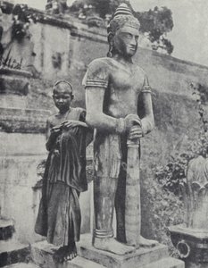 Ung buddhistisk nybörjarmunk bredvid en staty av Buddha, Franska Indokina (s/v foto)