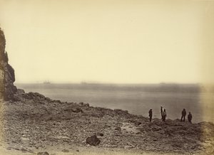[Vy över stranden med fartyg i horisonten och fem personer som står på stranden] av Felice Beato
