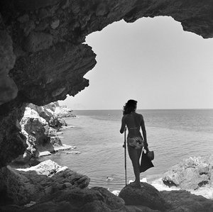 Badare på klippan som tittar ner mot havet nära byn Aspra, nära Palermo, Sicilien, ca 1950 (svartvitt foto) av Fosco Maraini