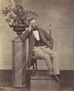 [Mathias Höusermann sittande med armbåge på piedestal med en vas med blommor], 1850-60-tal.