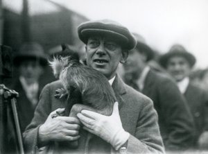 En svartkrönad Mangabey, möjligen fräknar, med sin förare, som deltar i en extern sändning från London Zoo, 1925 av Frederick William Bond