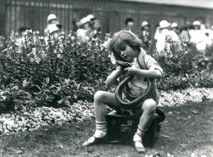 En ung flicka Betty som håller en östlig indigorm när hon sitter på en läderkoffert, London Zoo, 1924 av Frederick William Bond