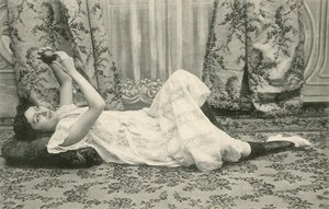 Flicka som ligger på golvet och håller en boll ovanför huvudet (s/v foto) av French Photographer