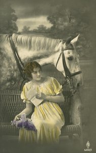 Flicka sitter på soffan med vit häst bakom (färgfoto) av French Photographer