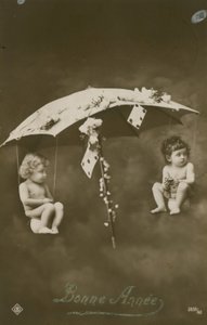 Gott nytt årskort med två bebisar hängande i ett paraply, skickat 1913 av French Photographer