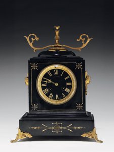 En mantelklocka av svart kompositionssten, med inskuren dekor, med ben, finials och beslag i förgylld mässing, av Jausions of Pau, Frankrike, ca 1876-78 av French School
