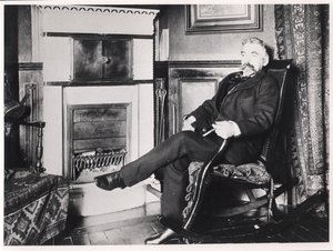 Stephane Mallarme (1842-98) sittande vid den öppna spisen i sitt hem på Rue de Rome, Paris av French School