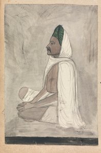 Man i en grön turban sitter med korsbenen
