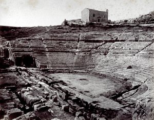 Resterna av den grekiska teatern i Siracusa i Neàpolls monumentala park. I förgrunden den halvcirkelformade orkestern och cavean av Giorgio Sommer