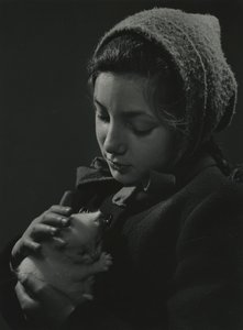 Flicka håller en vit kattunge i famnen. Tidigt 1950-tal