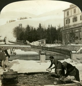 Kvinnor som tvättar kläder vid den offentliga fontänen i midvintern, Zuoz, Schweiz