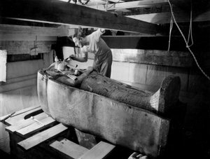 Upptäckt av farao Tutankhamons grav i Konungarnas dal (Egypten): i gravkammaren, Howard Carter som arbetar på locket till den andra kistan, oktober 1925, foto av Harry Burton (s1568)