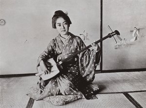 En geisha som spelar samisen (s/v foto) av Herbert Ponting