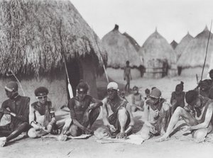 Afrika: Shilluk-krigare gnider in sig med träaska (svartvitt foto) av Hugo Adolf Bernatzik