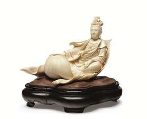 En elfenbensristning av Kannon flytande på ett lotusblad, Meiji-period, sent 1800-tal (elfenben med trästativ) av Ishikawa Komei