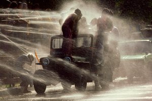 Människor besprutas vid vattenfestivalen under det buddhistiska nyåret. Mandalay, Burma. av James L Stanfield