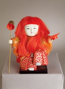 Festivaldocka av en tjänare som håller en skopp och maträtt av Japanese School