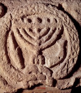 Judendom: arkitektoniskt element i basalt av en synagoga dekorerad med en ljusstake med sju grenar (menora eller menora), palm och trumpet. Från Transjordan. Omkring 100 e.Kr. Paris, Louvren av Jewish School