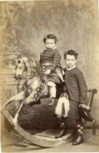Ung flicka på gunghäst med ung pojke i kilt, 1860-talet (albuminprint)