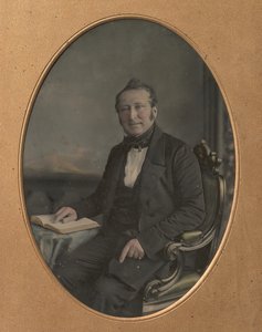 Sittande man som pekar på en passage i en öppen bok, 1850-talet.