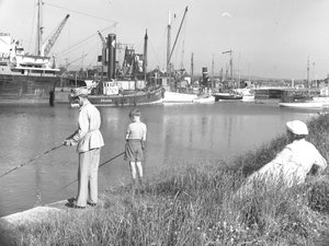 En man och en pojke fiskar i Glasson Dock medan en kvinna är till sjöss; havslandskap; bakom ser Ted på, olika båtar förtöjda av Joseph Hardman