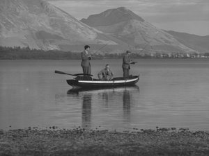 Tre män i en roddbåt på en sjö fiskar, en man är hav; havslandskap;ted, fjäll i bakgrunden av Joseph Hardman