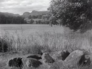 Vy över Loughrigg Tarn, i förgrunden finns några stenar som är nedsänkta i marken av Joseph Hardman