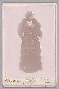 Skåpskort av en oidentifierad kvinna som bär en hatt och en pälsstol, ca. 1895. av Justus C. Swan