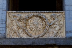Balustradplatta med strålande sol i girland, basrelief på fasaden av San Sebastiano-kyrkan