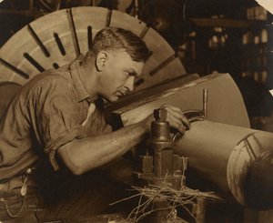 Man med mikrometer som mäter en axel till en tusendels tum. av Lewis W. Hine