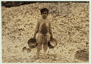 Manuel, 5 år gammal, migrerande räkplockare framför en hög med ostronskal, arbetar för andra året på Dunbar, Lopez, Dukate Company, Biloxi, Mississippi, 1911. av Lewis Wickes Hine