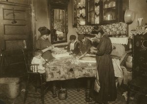 Mrs Mette och hennes barn (Josephine 13, Nicholas 6 och Johnnie 8 som tillsammans tjänar endast 40-50 cent per dag) gör blommor i en smutsig hyresrätt i New York, 1911. av Lewis Wickes Hine