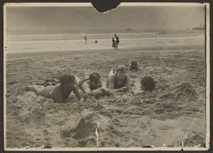 [Barn som ligger i sanden på stranden] av Louis Fleckenstein