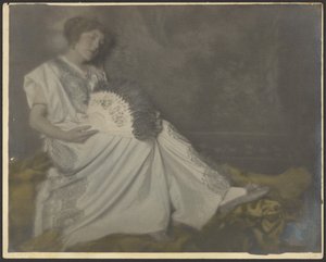 [Florens sitter med stor solfjäder] av Louis Fleckenstein