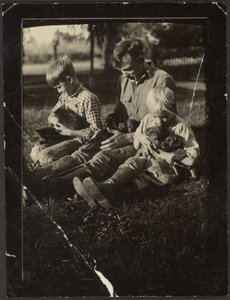 [Man med barn och hundvalpar på gårdsplanen] av Louis Fleckenstein