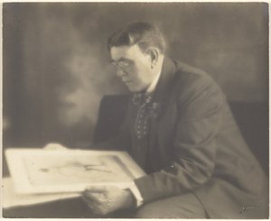 [Självporträtt i ateljén, medan jag betraktar ett fotografi av en ung flicka] av Louis Fleckenstein