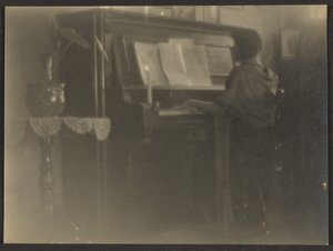 [Kvinna som spelar piano] av Louis Fleckenstein