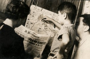 En kvinna läser framsidan av The Messenger med titeln "Trikoloren vajar segrande av Adwa återerövrade"