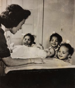 Sjuksköterskan Henry Street hjälper tre afroamerikanska flickor i Harlem, New York City av Luigi Leoni