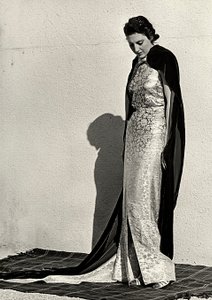 Modell i aftonklänning skapad av det italienska couturehuset "Dragoni". Artikeln kompletteras med en lång sammetsmantel (s/v foto)