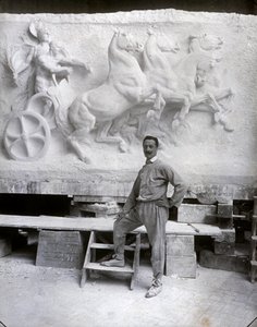 Hellängdsporträtt av den berömda skulptören Pietro Canonica. Han poserar i sin studio inför en marmorrelief som han arbetar på (s/v foto)