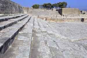 Minoiska arkeologiska platsen Phaistos. Den västra domstolen och teaterområdet. Stor stenlagd gård framför fasaden och den centrala ingången till palatset (1900 -1700 f.Kr.). Denna domstol spelade en viktig roll i invånarnas liv. Vid foten av av Minoan