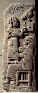 Låg basaltrelief föreställande skrivaren Tarhunpiyas på sin mors knän, med skriften och en jaktfalk. Slutet av 800-talet f.Kr. Från Marash, Anatolien. Neo-hittitisk tid (1050-800 f.Kr.) Dim. 0,75x0,28 m. Paris, Louvren av Neo Hittite Neo Hittite