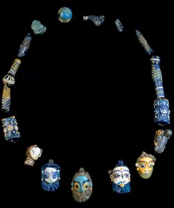 Halsband i glaspasta med hängen föreställande skäggiga huvuden, ursprungligen från Olbia, nu bevarat på National Archaeological Museum of Cagliari