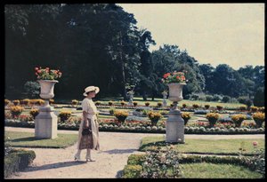 Kvinna promenerar i trädgården vid Bagatelle, Paris, ca 1920 (foto) av Photographer French