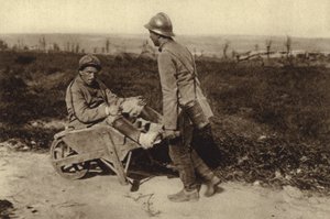 Fången fransk soldat som transporterade sin skadade kamrat i en skottkärra, första världskriget av Photographer German