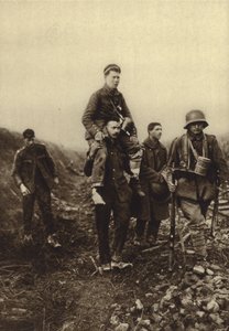 Tysk infanterist med ett bensår som bärs från slagfältet av brittiska fångar, första världskriget av Photographer German