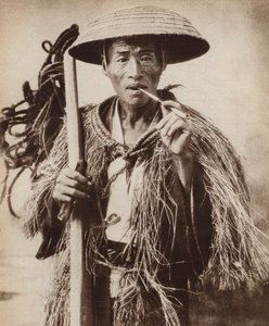 Japansk coolie (lantarbetare) bär en hatt för att skydda honom från kraftigt regn i risfälten (s/v foto)