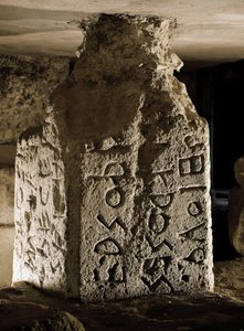 Borne (eller cippe) av Forum Romanum (Foro Romano) som finns under bågen av Septime Severe. Graverad inskription på latin. 600-talet f.Kr. Rom, Forum Romanum - Stele (cippus) med graverad text på latin av en helig lag, från Lapis Niger. Sten, 600-talet av Roman