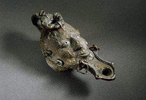 Romersk konst: oljelampa i brons i form av ett ansikte. 1:a eller 2:a århundradet e.Kr. Spaniens museum i Ampurias (Empurias) av Roman